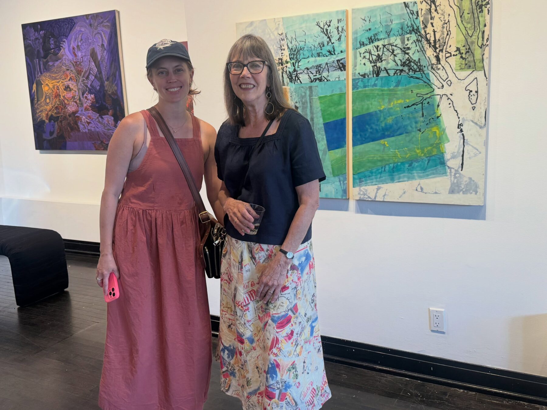 Visitors at the Art In Transit opening beside an encaustic diptych